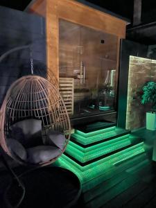 a room with a chair in a room with green lights at Z Apartmanház in Zalaegerszeg