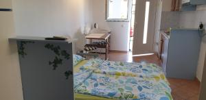 Apartments LAGUNA 20, 20A في إيزولا: غرفة صغيرة بها سرير ومطبخ