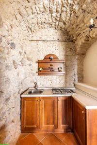 a kitchen with a sink and a stone wall at Luxury Accommodation in Santa Domenica