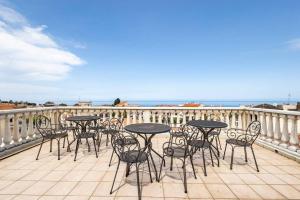 a group of tables and chairs on a balcony at Luxury Accommodation in Santa Domenica