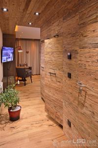 Berghotel Pointenhof في سانت جوهان في تيرول: جدار خشبي كبير في غرفة مع بيانو