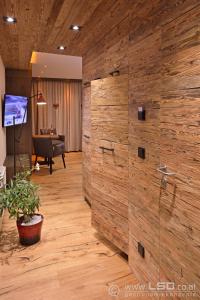 una gran pared de madera en una habitación con piano en Berghotel Pointenhof, en Sankt Johann in Tirol