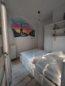 sypialnia z łóżkiem i obrazem na ścianie w obiekcie Apartment Ksiecia Witolda 43 we Wrocławiu