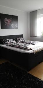 1 cama en un dormitorio con marco de cama negro en FEWO Emsland, en Emsbüren