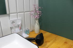 a room with a white vase with flowers in it at Апартаменты Comfort Life 93 in Almaty