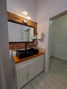 W łazience znajduje się czarna umywalka i lustro. w obiekcie Apartment Ksiecia Witolda 43 we Wrocławiu