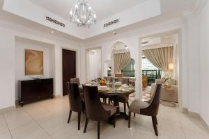 a dining room and living room with a table and chairs at Maison Privee - Tasteful Apt cls to Burj Khalifa & Dubai Mall in Dubai