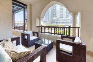 a balcony with wicker furniture and a view of a city at Maison Privee - Tasteful Apt cls to Burj Khalifa & Dubai Mall in Dubai