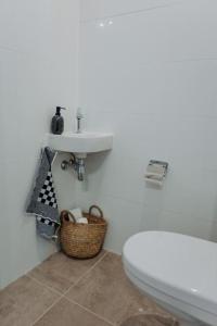 a white bathroom with a sink and a toilet at Brand new bright & luxurious villa in Amsterdam! in Amsterdam