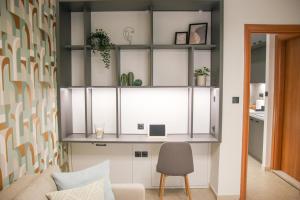 uma sala de estar com armários brancos e uma cadeira em CasaTu 2 Apartments em Comotini