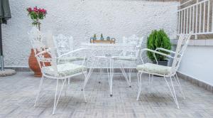 - une table et des chaises blanches sur la terrasse dans l'établissement CasaTu 2 Apartments, à Komotiní