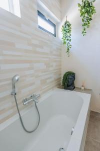 a bathroom with a bath tub with a shower at Brand new bright & luxurious villa in Amsterdam! in Amsterdam