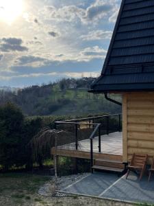 une terrasse en bois avec un banc et une maison dans l'établissement Willa Gocówka & SPA, à Bukowina Tatrzańska