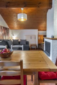 Una sala de estar con una mesa de madera y un sofá. en Residenza Lagorai, en Castello di Fiemme
