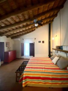 1 dormitorio con 1 cama grande con manta a rayas en Dúplex con piscina en centro Cazalla, en Cazalla de la Sierra