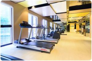 a row of treadmills in a gym with windows at April Apartment in Ho Chi Minh City
