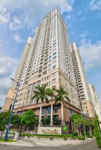 a large white building with palm trees in front of it at April Apartment in Ho Chi Minh City