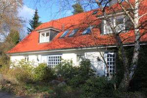 een wit huis met een oranje dak bij Ferienwohnung Amselstieg Dr Meier in Bad Bevensen
