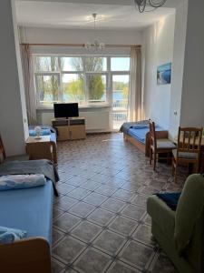a room with two beds and a tv and a couch at Rybitwa in Dziwnów