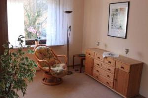 een kamer met een stoel, een dressoir en een raam bij Ferienwohnung Amselstieg Dr Meier in Bad Bevensen