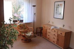 a room with a chair and a dresser and a window at Ferienwohnung Amselstieg Dr Meier in Bad Bevensen