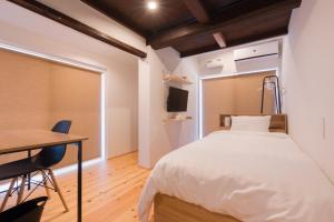 a bedroom with a bed and a desk and a television at FARMSTAY miyuki-street "Goen" in Ukiha