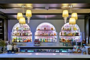 - un bar avec plusieurs étagères de bouteilles d'alcool dans l'établissement Epoque Hotel - Relais & Chateaux, à Bucarest