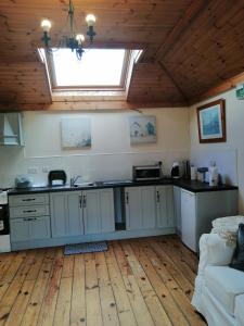 a kitchen with white cabinets and a skylight at An Cúinín in New Ross