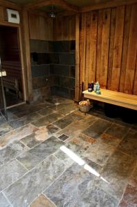 baño con suelo de piedra y banco en Hotel Buxus en Gasselte