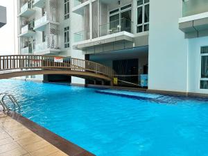 a large swimming pool with a bridge in a building at KSL 2Bedroom with WiFi Netflix 58 inch TV high floor balcony in Johor Bahru