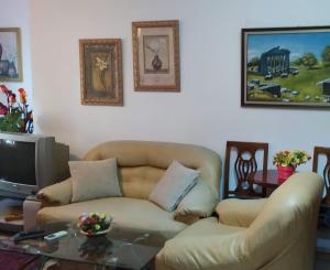 - un salon avec un canapé et une télévision dans l'établissement Holiday apartment Shengjin, à Shëngjin