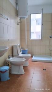 a bathroom with two toilets and a shower and a sink at Holiday apartment Shengjin in Shëngjin