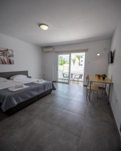 a bedroom with a bed and a table and chairs at Nissi avenue studio in Ayia Napa
