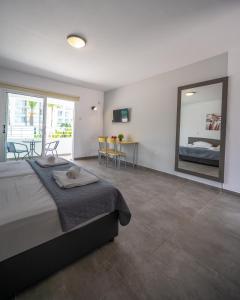 a bedroom with a large bed and a large mirror at Nissi avenue studio in Ayia Napa