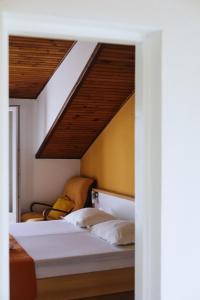 um quarto com uma cama e uma cadeira num quarto em Apartments Fora - Hvar em Hvar