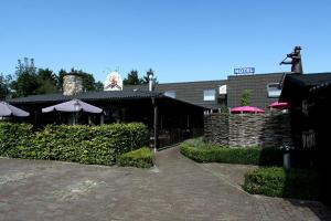 a restaurant with umbrellas in front of a building at Hotel Buxus in Gasselte