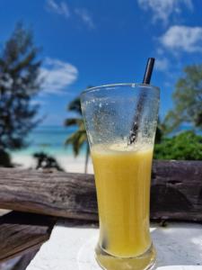 a glass of orange juice sitting on a table at Ayla Beach House in Kiwengwa