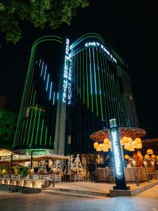 un hôtel avec un panneau devant lui la nuit dans l'établissement Grand Mildom Hotel, à Almaty