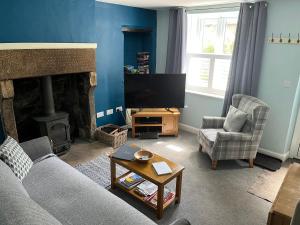 a living room with a couch and a fireplace at Poppy Cottage in Matlock