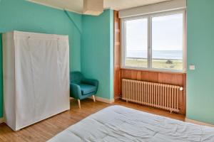 パンマールにあるEchappee relaxante au bord de l ocean a Penmarchのベッドと椅子と窓のある寝室 +21枚の写真