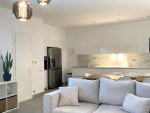 een woonkamer met een witte bank en een keuken bij LUXURY VILLA SEVEN in Skiathos-stad