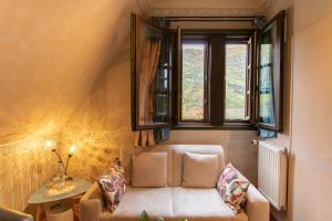 ein Wohnzimmer mit einem Sofa und 2 Fenstern in der Unterkunft Hotel Weinhaus Weiler in Oberwesel