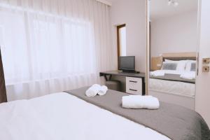 um quarto branco com uma cama e um espelho em Varna city centre - two bedroom apartment em Varna City