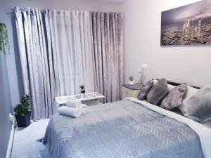 a white bedroom with a large bed and a window at Burburry Studio Apartments in Cleethorpes