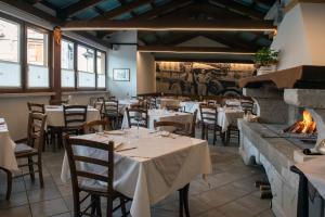 un restaurante con mesas y sillas y una chimenea en Albergo Alla Cesa, en Feltre