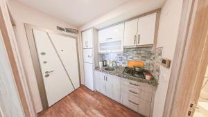 a small kitchen with white cabinets and a sink at Cozy flat close to Konyaaltı beach '6' in Antalya