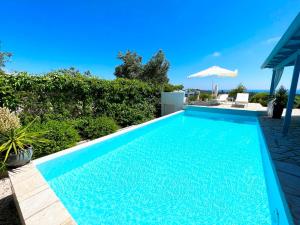 a swimming pool with blue water in a yard at Myrtle Cottage in Vlachopoulátika +12 photos