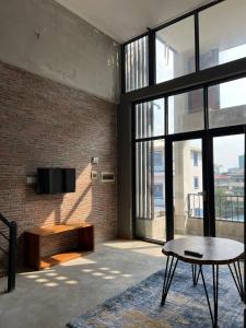 a living room with a tv on a brick wall at liora Cambodia - Riverside Loft Apartments in Phnom Penh