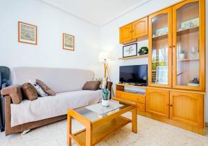 een woonkamer met een bank en een tv bij Vallejos ID58 in Torrevieja