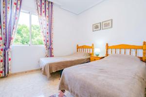 2 bedden in een slaapkamer met een raam bij Vallejos ID58 in Torrevieja